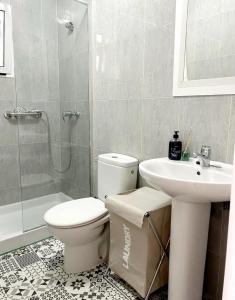 een badkamer met een toilet, een wastafel en een douche bij Maravilloso apartamento en el centro in Ceuta