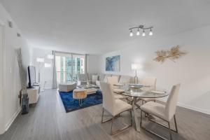 een woonkamer met een tafel en stoelen en een bank bij Great Apartment in Brickell in Miami