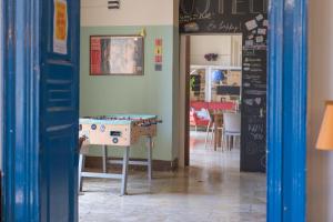 een eetkamer met een tafel en een schoolbord bij Ostello degli Elefanti in Catania