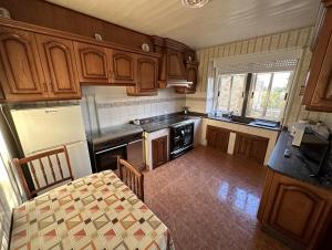 a kitchen with wooden cabinets and a table with a tableablish at Casa Balteiro in Cedeira