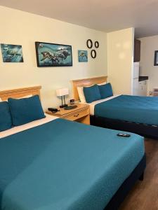 um quarto de hotel com duas camas com lençóis azuis em Beachside Hotel - Daytona Beach - NO POOL em Daytona Beach