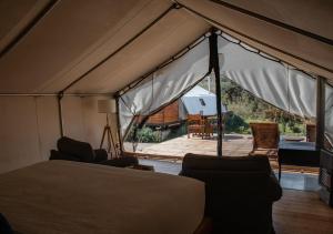 a tent with a bed and chairs and a patio at Hotel Cuatro Cuatros in Ensenada +99 photos