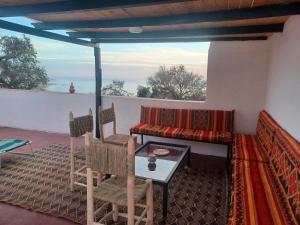 een kamer met een tafel en stoelen op een balkon bij Superbe appartement , grande terrasse vue mer et montagne Taghazout in Taghazout