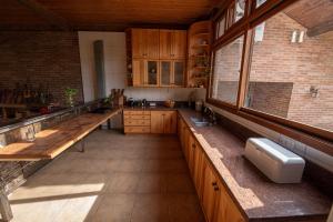cocina grande con armarios de madera y ventana grande en Monã, en Canela 23 fotos más