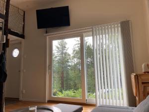 a living room with a large sliding glass door at Fullt utrustat Minihus på landet in Västerhaninge