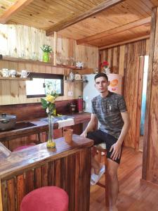 un hombre sentado en un mostrador en una cocina en Cabaña San José PY, 