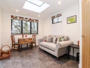 a living room with a couch and a table at Herdwick Cabin in Penrith