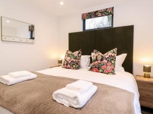 a bedroom with a large bed with two towels on it at Herdwick Cabin in Penrith