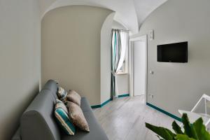 a living room with a couch and a flat screen tv at Amalfi Apartments Design centro storico in Amalfi