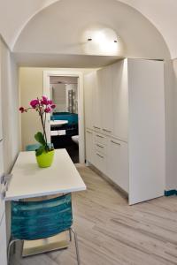 a kitchen with a table and a vase with a flower on it at Amalfi Apartments Design centro storico in Amalfi