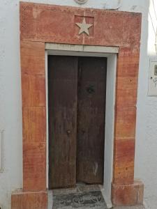 an old wooden door with a star on top at Dar Azur Hammamet Guest House in Hammamet