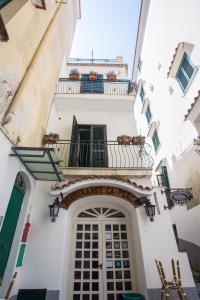 Edificio blanco con balcón y puerta en Amalfi Apartments Design centro storico, en Amalfi