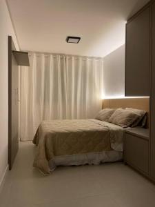 um quarto branco com uma cama e uma janela em Apartamento na praia do Ingleses Gaivotas em Florianópolis