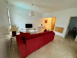 a living room with a red couch and a table at Apartamento Deluxe Ciudad Jardin in Las Palmas de Gran Canaria