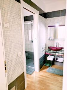 La salle de bains est pourvue d'une douche et d'un lavabo rouge. dans l'établissement Appartamento con terrazzo privato Milano San Raffaele Linea verde, à Vimodrone