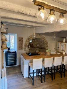 une cuisine avec une table et des chaises dans une pièce dans l'établissement L'écrin, charmant cottage aux portes de la cité médiévale de Semur-en-Auxois, à Chevigny