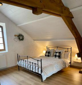 une chambre avec un lit dans un grenier dans l'établissement L'écrin, charmant cottage aux portes de la cité médiévale de Semur-en-Auxois, à Chevigny