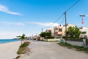 an empty street next to the beach with a house at Beautiful country house in front of the sea in Polychrono