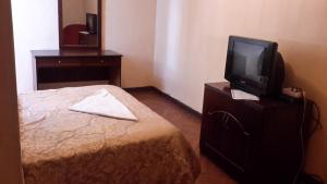 um quarto com uma cama e uma televisão numa cómoda em 70 Dereja Hotel em Addis Ababa