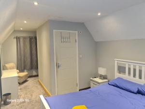 een slaapkamer met een blauw bed en een deur bij The Reading whole apartment with private lake and gardens in Reading