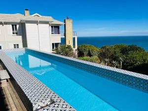 a swimming pool with a view of the ocean at Luxury Home located on Pinnacle Point Golf Estate in Mossel Bay