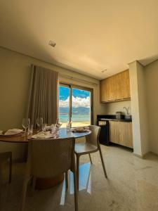 una sala da pranzo con tavolo e sedie e una cucina di Ágape Suítes & Apartamentos a São Sebastião