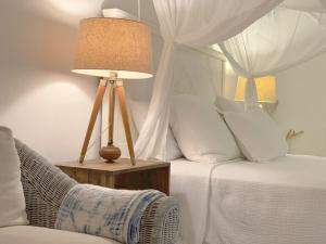 una camera da letto con un letto con una lampada e una sedia di Monte Sagrado Reserve - wellnessTanama Riverfarm cabin a Quebrada