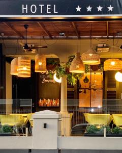 a restaurant with yellow tables and chairs and lights at Hotel on the Promenade in Cape Town