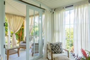 sala de estar con puertas correderas de cristal y balcón en Private Villa at Monte Sagrado Reserve villa en Quebrada