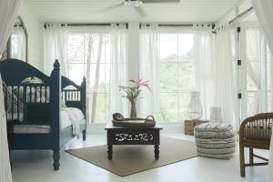 um quarto com uma cama azul e uma mesa com uma planta em Monte Sagrado Reserve Villa - Tanama River, Farm villa em Quebrada