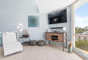 uma sala de estar com uma televisão de ecrã plano na parede em Ocean View Penthouse with pool, beachfront complex apts em Río Grande