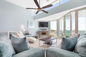 uma sala de estar com um sofá e uma ventoinha de tecto em Ocean View Penthouse with pool, beachfront complex apts em Río Grande
