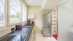 a kitchen with a sink and a refrigerator at Le SAPHIR - Confort - Proche Mag Outlet Troyes - Parking gratuit in Pont-Sainte-Marie