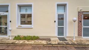 una casa bianca con due porte e una finestra di Le SAPHIR - Confort - Proche Mag Outlet Troyes - Parking gratuit a Pont-Sainte-Marie