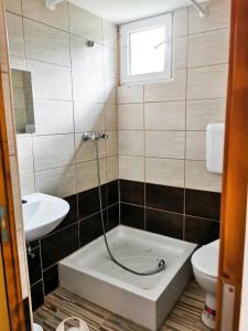 a bathroom with a tub and a sink and a toilet at Köröstorok Apartmanok in Csongrád