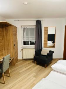 ein Schlafzimmer mit einem Bett, einem Stuhl und einem Spiegel in der Unterkunft Bold´S Hotel-Restaurant "Zum Grünen Kranz" in Rodalben