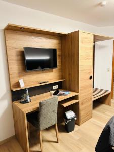 Zimmer mit einem Schreibtisch, einem TV und einem Stuhl in der Unterkunft Bold´S Hotel-Restaurant "Zum Grünen Kranz" in Rodalben