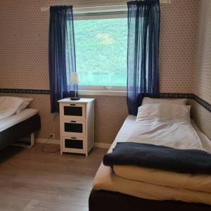 a small bedroom with a bed and a window at Lake View Apartment, Oldedalen in Stryn