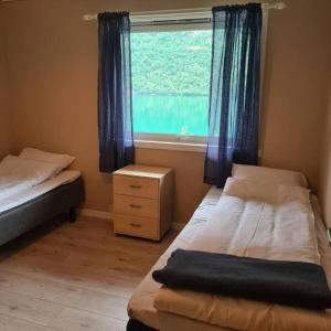 een slaapkamer met 2 bedden en een raam bij Lake View Apartment, Oldedalen in Stryn