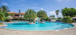 una gran piscina con palmeras en un complejo en Vakantie appartement Seru Coral Resort Curaçao, en Willemstad