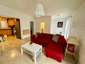 a living room with a red couch and a table at Apartamento Deluxe Ciudad Jardin in Las Palmas de Gran Canaria