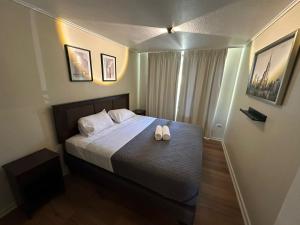 ein Schlafzimmer mit einem Bett mit zwei Hausschuhen darauf in der Unterkunft Calafquen Viña del mar in Viña del Mar
