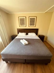 a bedroom with a bed with two towels on it at Calafquen Viña del mar in Viña del Mar