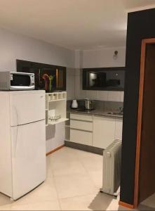 a kitchen with a white refrigerator and a microwave at Complejo del Este in San Carlos de Bariloche
