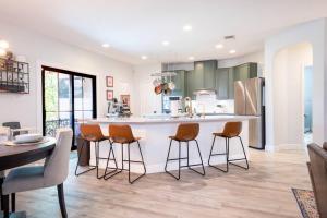 una cocina con una gran isla blanca con taburetes de bar en Luxe Home-Designer BTHRM-Covered Deck-Weber Grill en San Antonio