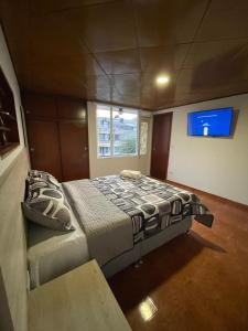 a large bed in a room with a window at Hostel Movistar Arena in Bogotá
