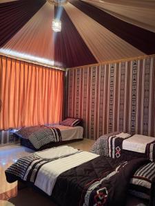 a room with three beds in a tent at Magic nature camp in Wadi Rum