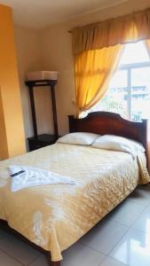 Schlafzimmer mit einem großen Bett und einem Fenster in der Unterkunft Hotel Mirador Sacha in La Joya de los Sachas