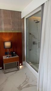 a bathroom with a shower and a table with a lamp at Hotel Nacional in Rio de Janeiro