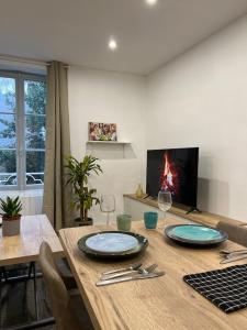a dining room table with two glasses and a fireplace at * Cosy & Netflix Proche Centre * in Nantes +6 photos